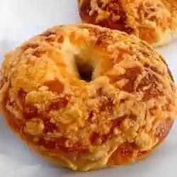 Asiago cheese bagel on a white plate.
