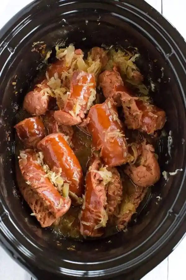 This slow cooker kielbasa and sauerkraut is flavorful and made with just the addition of beer and brown sugar - straightforward, rich and reliable for parties!