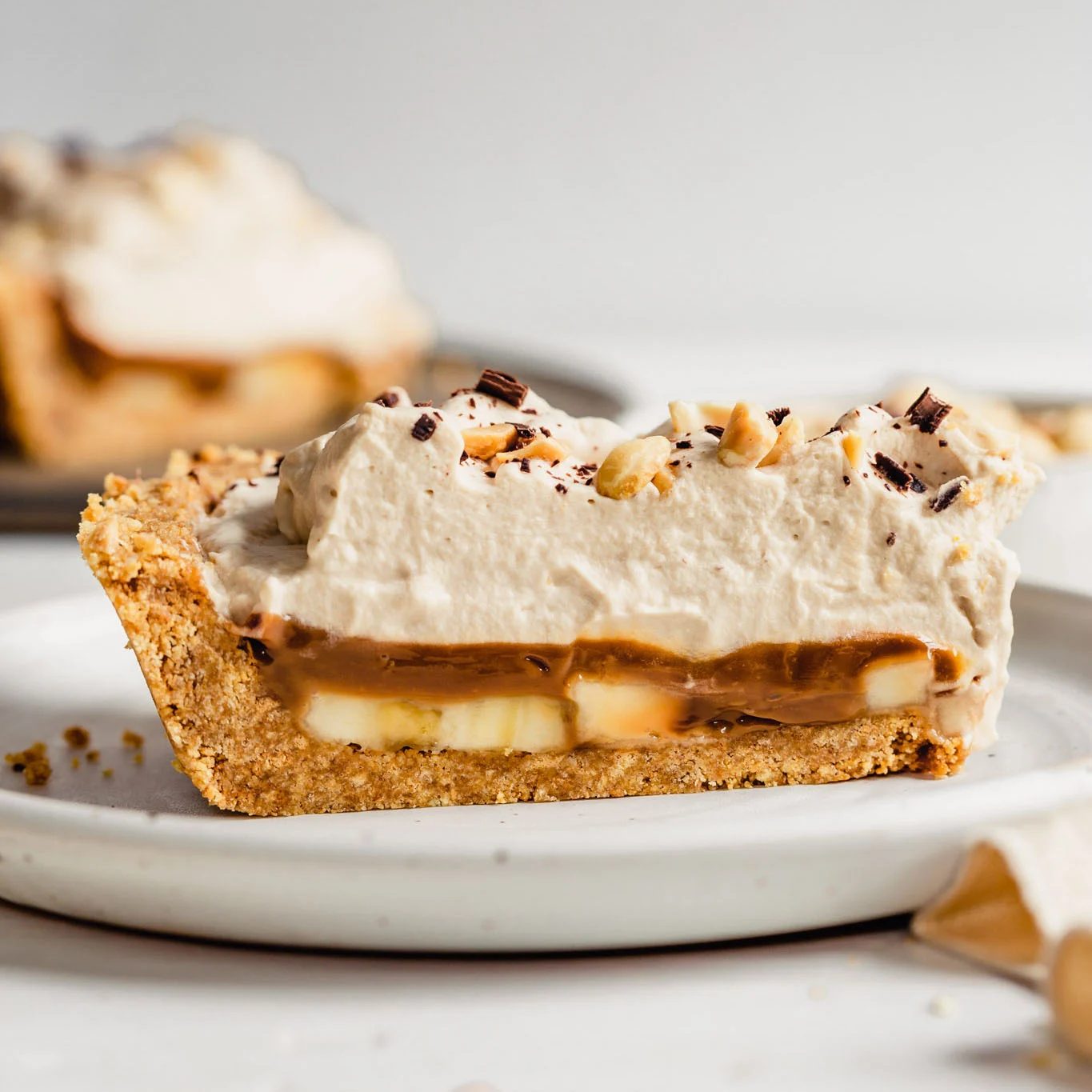 Slice of banoffee pie on a white plate.
