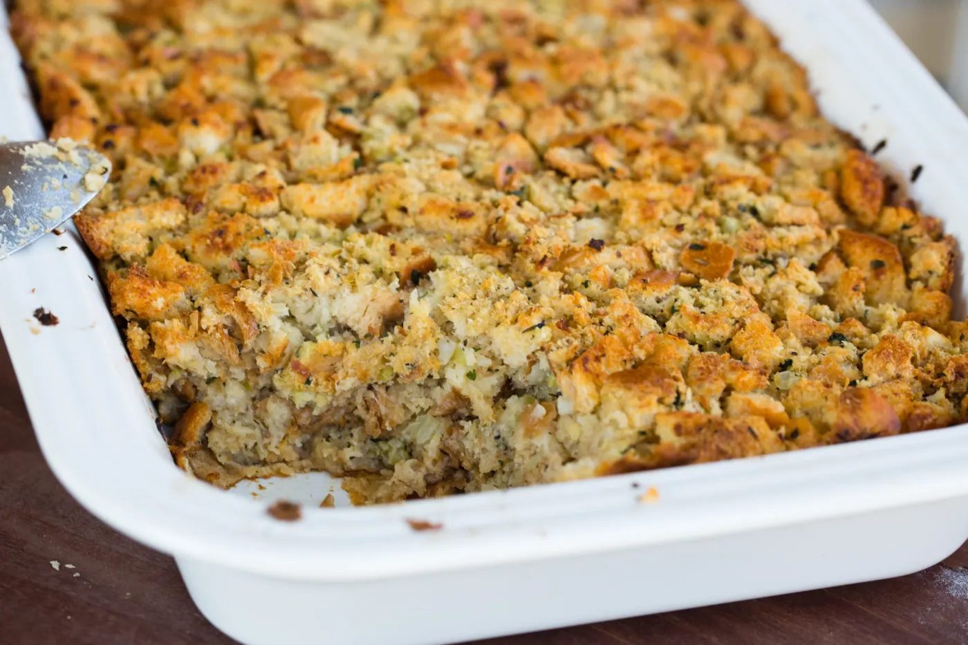 Pan of classic bread stuffing with a scoop removed.