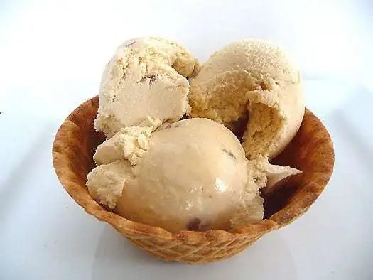 Scoops of butter pecan ice cream in a waffle bowl.
