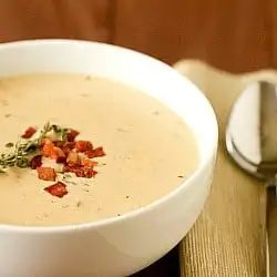 Cheddar cheese soup in a white bowl.