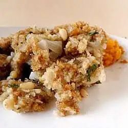 A serving of bread stuffing on a white plate.