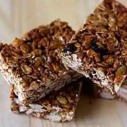 3 granola bars on a wood surface.