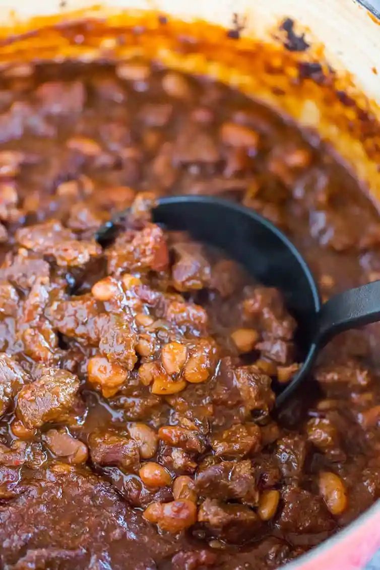 Chili con carne in a pot, with a ladle scooping some out.