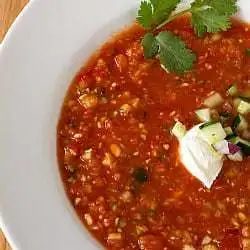Overhead image of gazpacho in a white bowl.