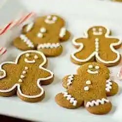 Decorated gingerbread men cookies on a white plate.