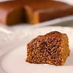 Slice of gingerbread cake on a white plate.