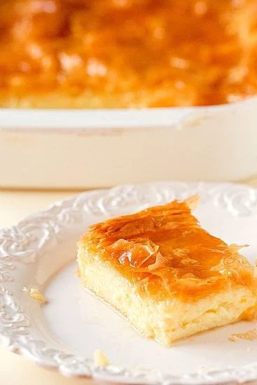 Square of Greek custard pie on a white plate.