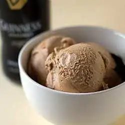 Scoops of Guinness milk chocolate ice cream in a white bowl with a spoon.