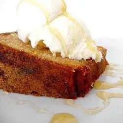 Slice of honey vanilla sour cream pound cake topped with vanilla ice cream and a drizzle of honey.