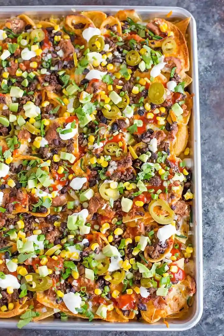 A sheet pan full of loaded nachos.