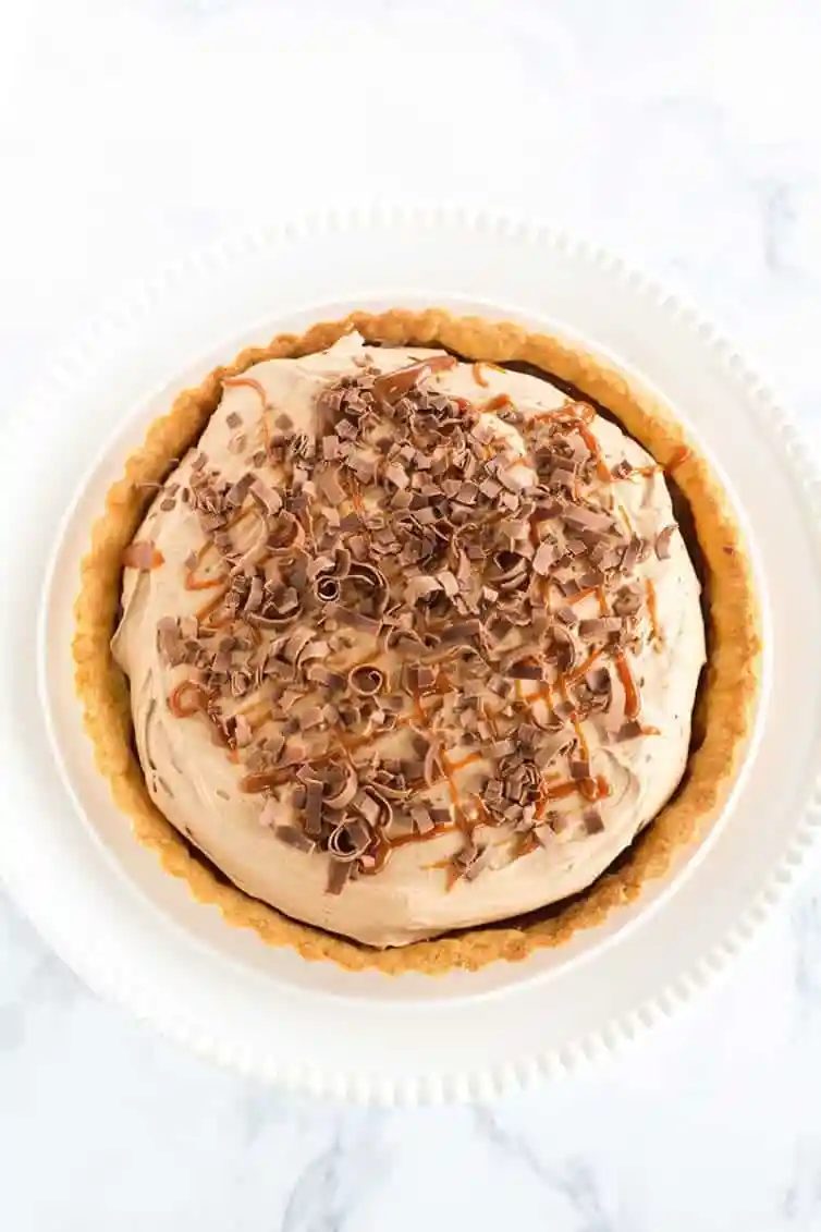 Milky Way Tart - A pate sucree crust is filled with caramel sauce and whipped milk chocolate ganache, then topped with a drizzle of caramel and chocolate curls.