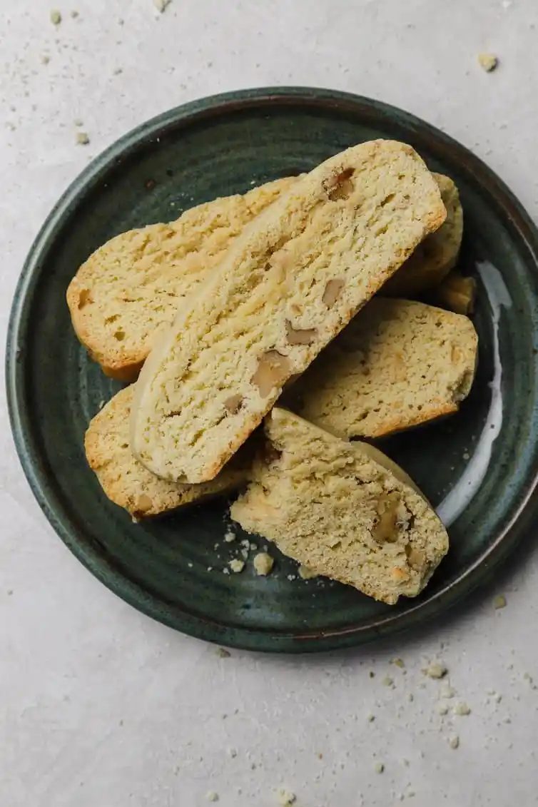 Biscotti stacked on a dark plate.
