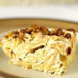 Square of noodle kugel on a cream colored plate.
