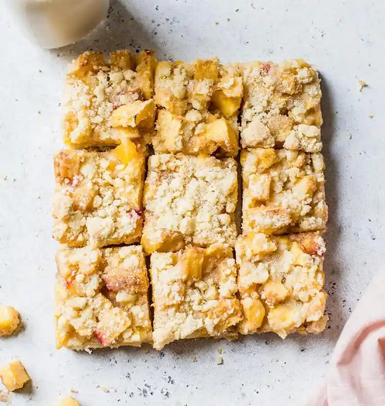 Peach crumb bars cut into nine squares.