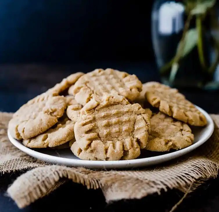 A plate piled high with peanut butter cookies.