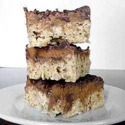 Stack of 3 peanut butter cup Rice Krispies treats on a white plate.