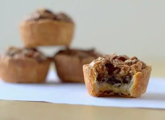 Pecan tassies with a bite taken from one.