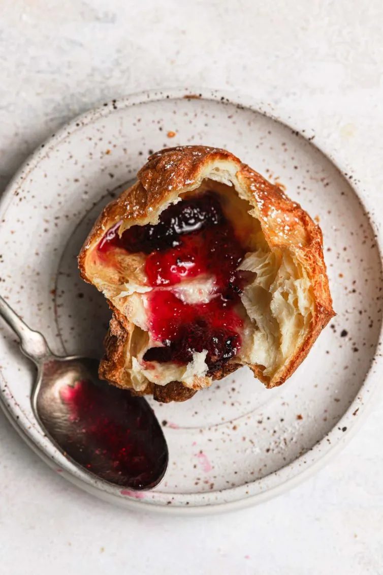 Straightforward popovers sliced in half and served with butter and strawberry jelly