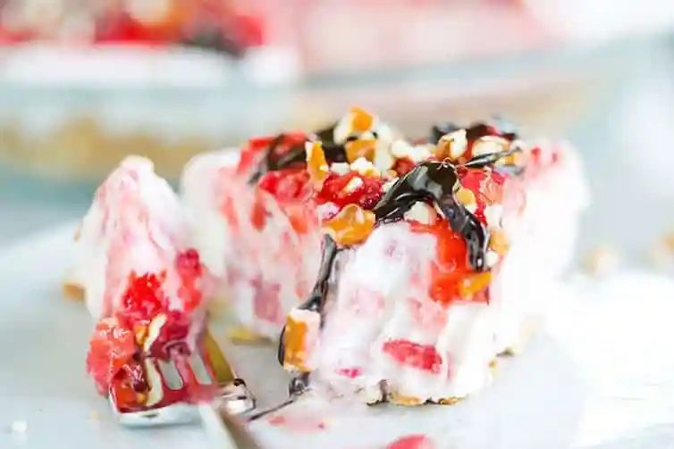 Taking a big bite out of a slice of Pretzel Strawberry Ice Cream Pie