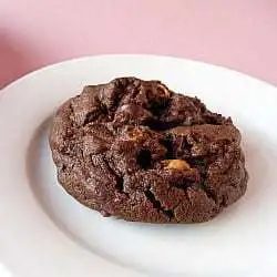 A salted double chocolate peanut butter cookie on a white plate.