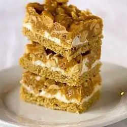 Stack of 3 salted peanut chew bars on a white plate.