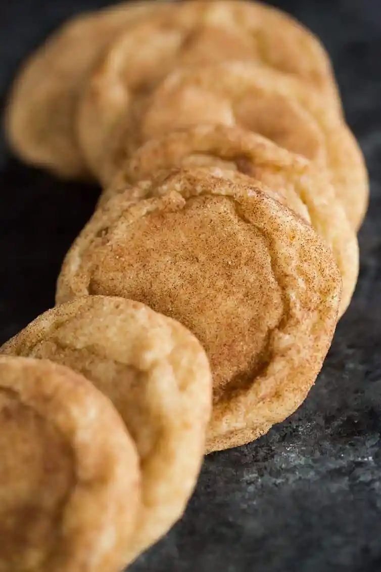 A display of snickerdoodle cookies on a dark serving plate.