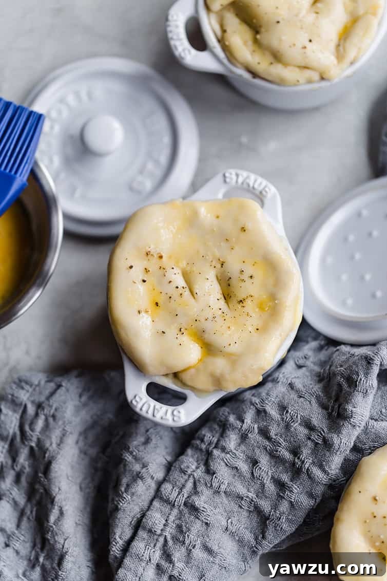 Assembled chicken pot pie in a ramekin with dough on top.