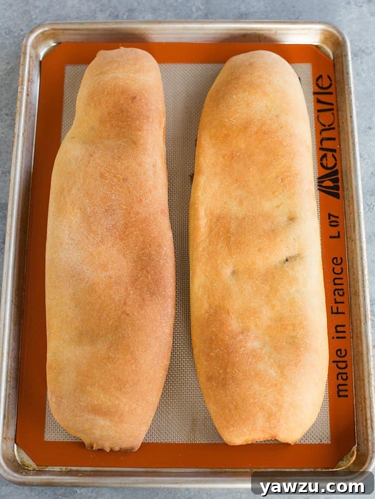 Close-up of a golden-brown, baked nut roll, ready to be sliced and enjoyed.