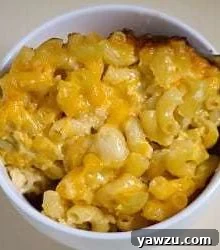 Baked macaroni and cheese in a white bowl with a spoon.