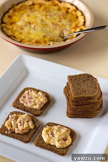 Hot reuben dip spread onto crackers on a white serving tray, highlighting its inviting texture.