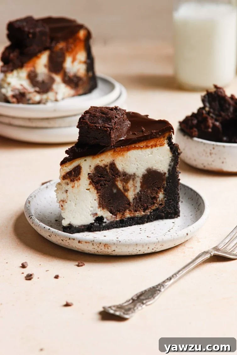 side view of this brownie cheesecake recipe with another slice in the background, showcasing its layers