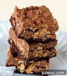 Close-up of a single Peanut Butter Cup Crunch Brownie Bar, showcasing the melted chocolate, crunchy Rice Krispies, and embedded peanut butter cups.