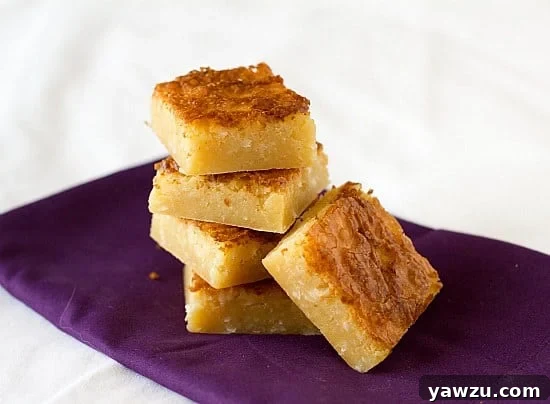 Stack of white chocolate coconut brownies on a vibrant purple napkin, ready to be enjoyed.