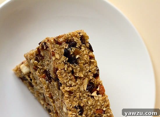 Overhead view of a beautiful stack of homemade granola bars on a white plate, showcasing their perfect texture and readiness for snacking.