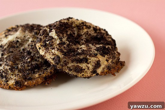 2 Oreo cheesecake cookies on a white plate, showcasing their rich texture and crumbly topping.