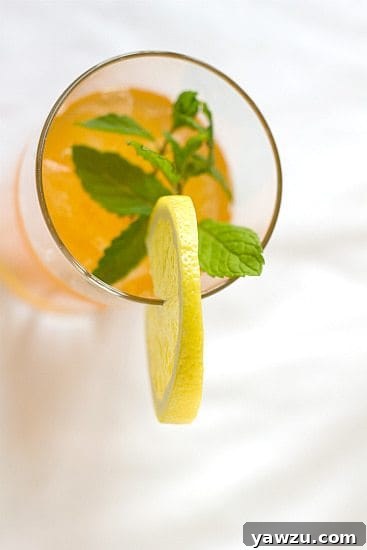 Overhead image of ginger tea lemonade in a glass garnished with a lemon round.