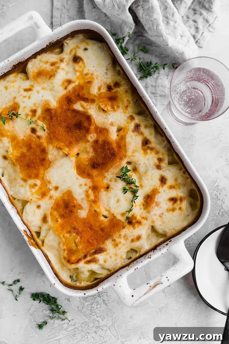 Small white bowl holding a serving of scalloped potatoes and a fork