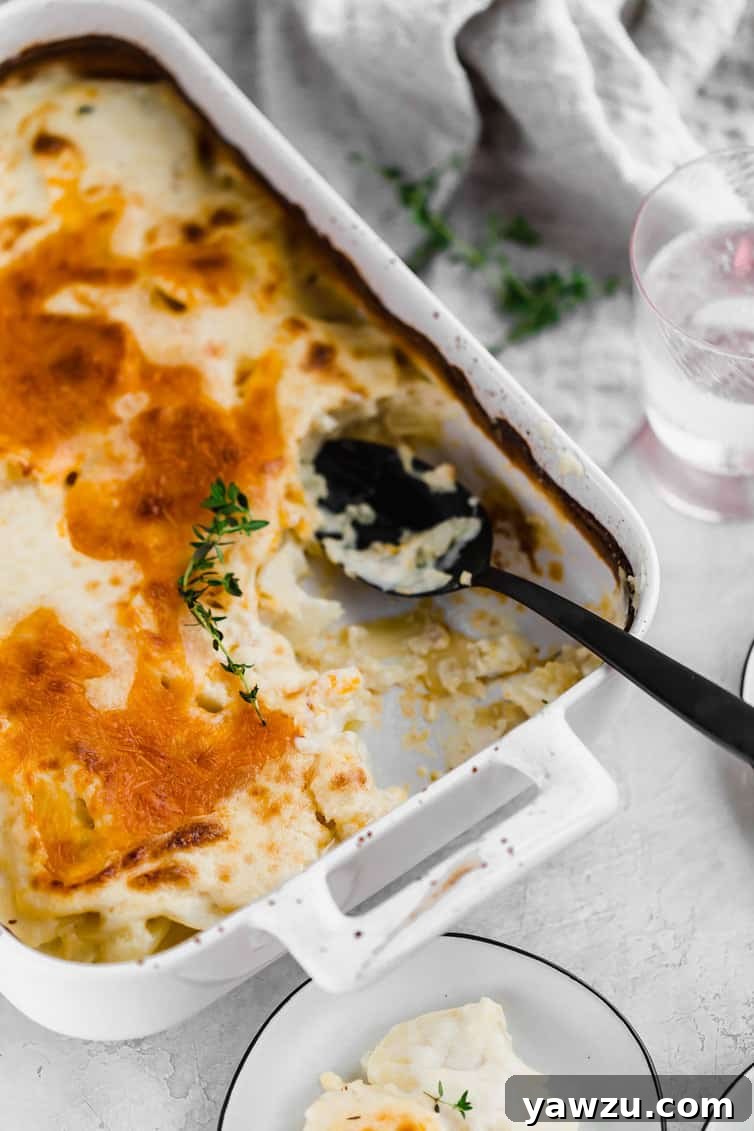 White casserole pan of scalloped potatoes after some has been spooned out