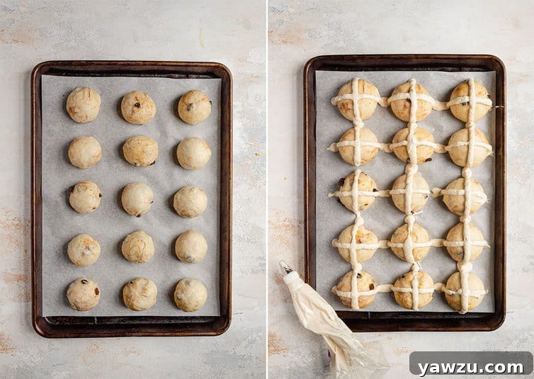 Hot cross buns being piped with white crosses on a baking sheet before going into the oven.