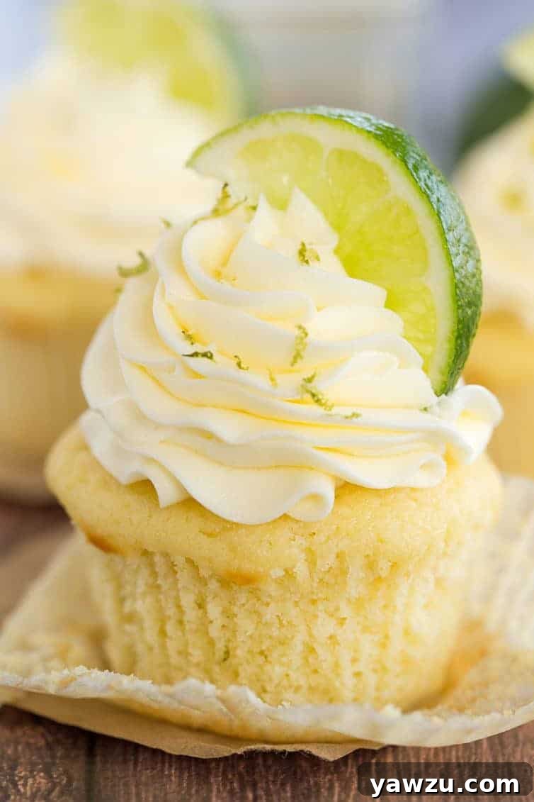 Margarita Cupcake - Vanilla cupcake with the paper liner pulled away. It's topped with lime zest and a lime wedge.