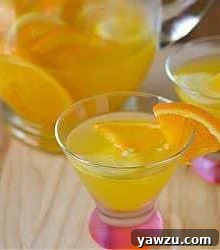 White sangria in cocktail glasses, garnished with orange slices.