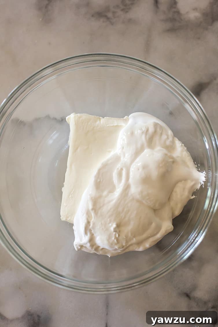 Cream cheese and marshmallow creme in a mixing bowl.