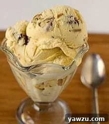Scoops of date, rum, and pecan ice cream in a glass bowl with a spoon.