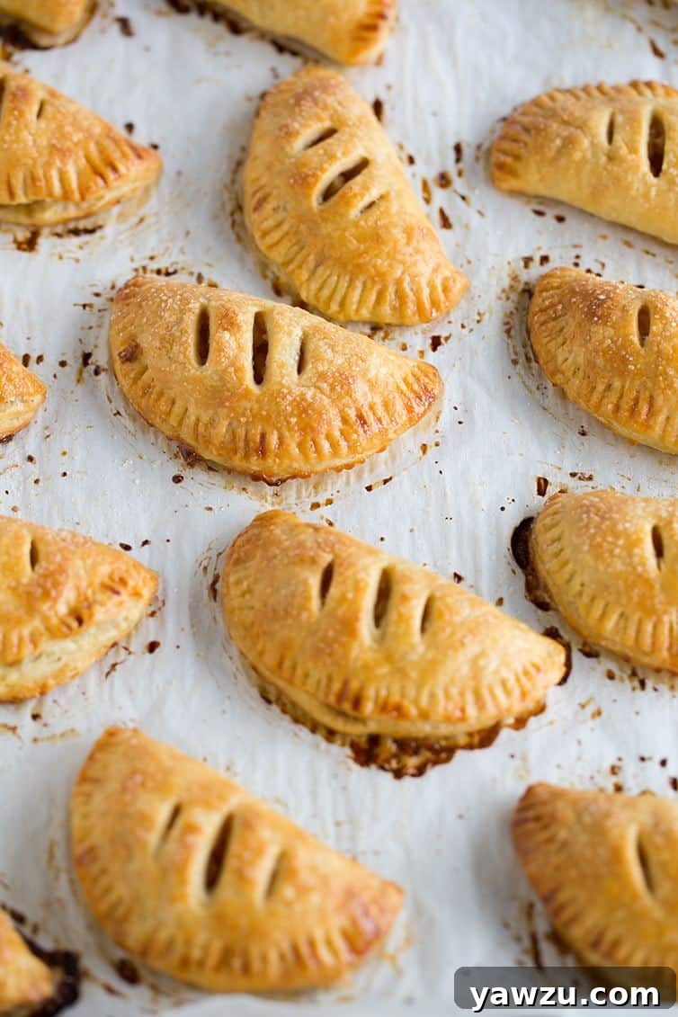 Freshly baked Apple Hand Pies cooling on a wire rack.