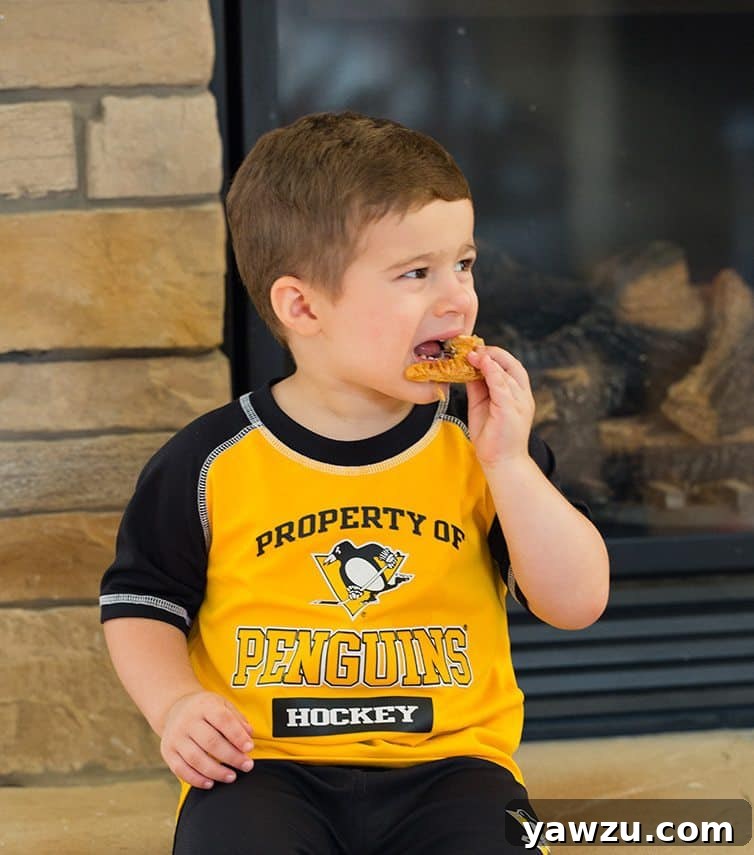 A young boy enjoying a freshly baked Apple Hand Pie.
