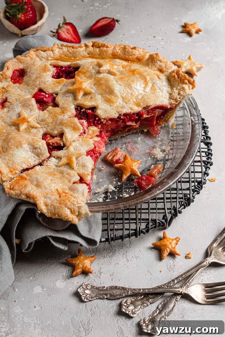 Strawberry rhubarb pie in pie plate with two slices missing.