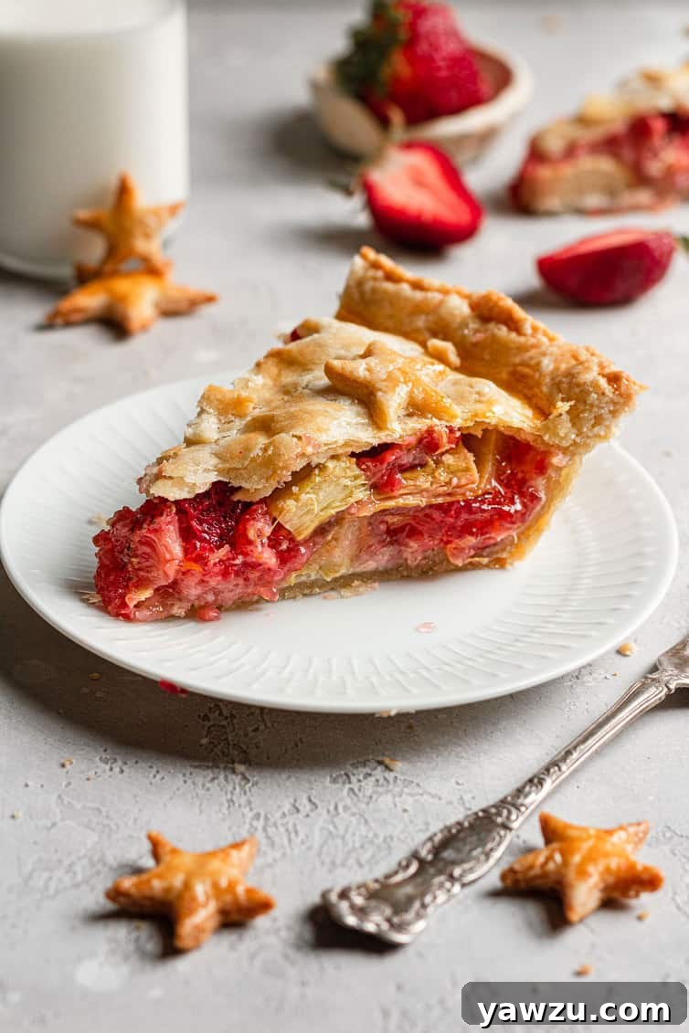 A slice of strawberry rhubarb pie on a white plate.