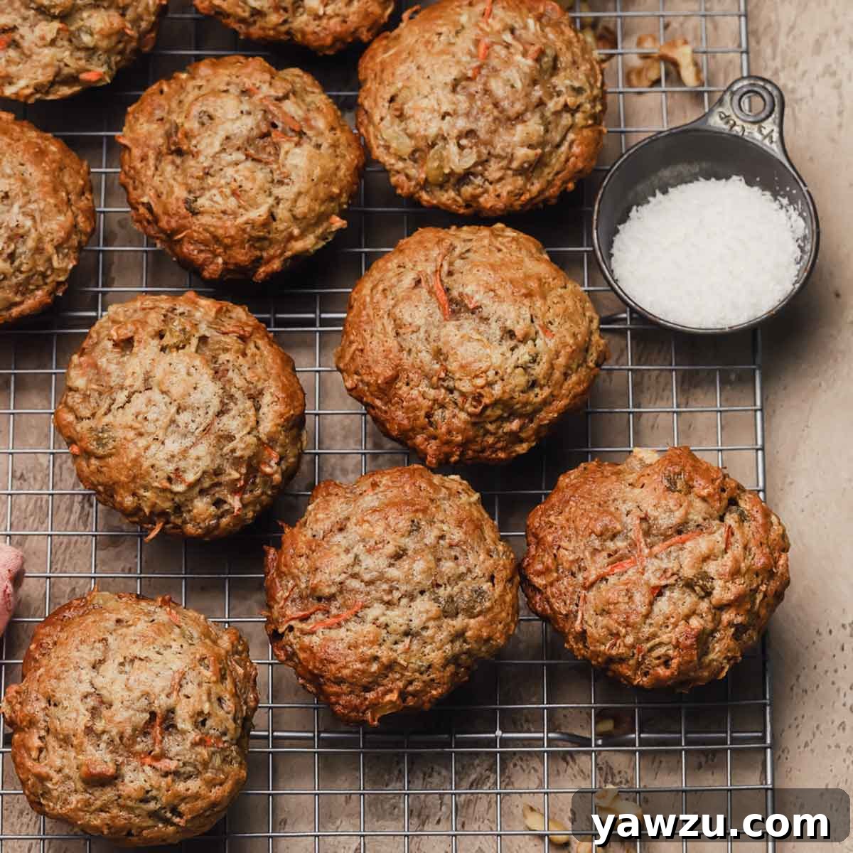 An array of beautifully baked Morning Glory muffins cooling on a wire rack, showcasing their wholesome ingredients and inviting texture.